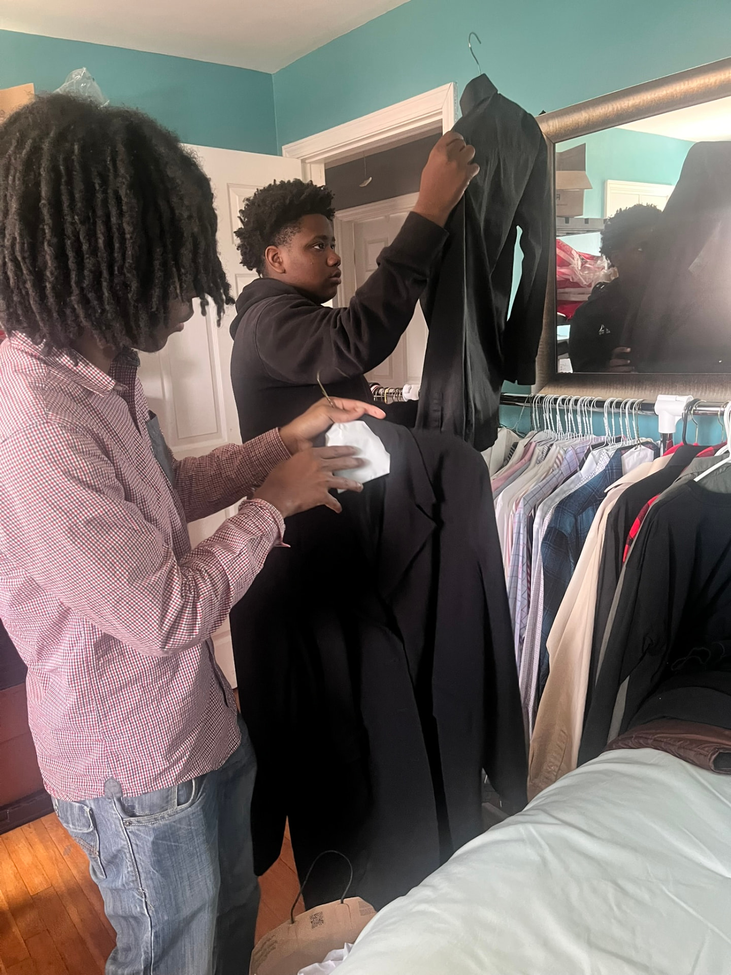 Young men picking out dress shirts and blazers from the FMG career closet